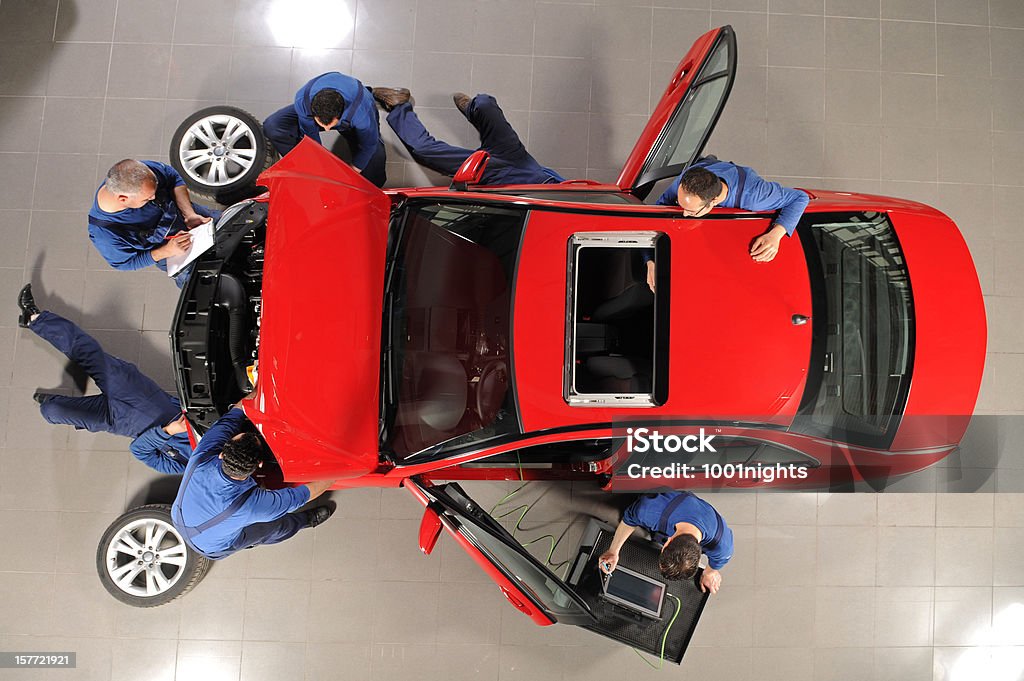 Auto mechanic team repairing the sports car Seven repairmen repairing the sports red car Car Stock Photo