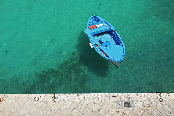 Blue boat from above in Salento coast, Puglia Italy