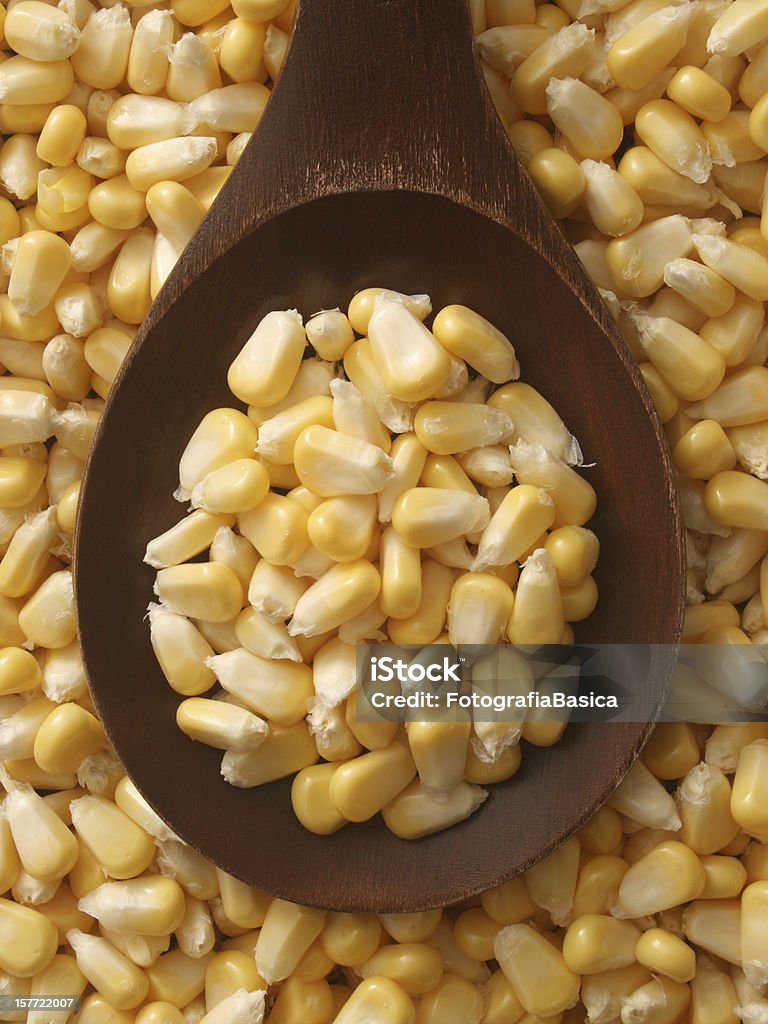 Corn kernels Top view of wooden spoon with raw corn grains on it Abundance Stock Photo