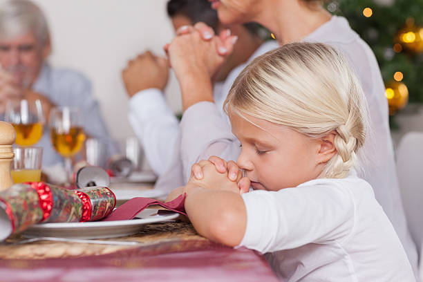 Family saying grace before dinner Family saying grace before christmas dinner saying grace stock pictures, royalty-free photos & images