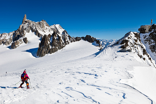 Chamonix, France - February 8, 2011: skier on the Glacier du Gẻant, a glacier of Mont Blanc massif located on the French side of the same. On the left you can see the famous peak Dent du Geant, 4014 m, on the right is the circular scenic terrace of the Pointe Helbronner station, at an altitude of 3500 meters above sea level.