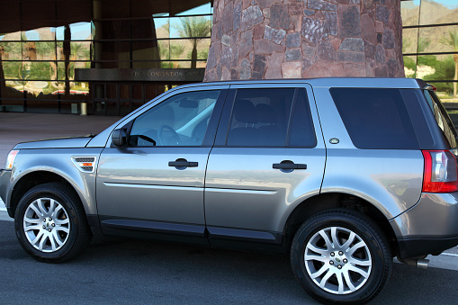 White SUV Car with the roof rack cargo box on road in Untertauern, Austria.