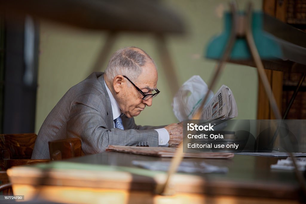Starszy włoski mężczyzna czytanie w bibliotece publicznej - Zbiór zdjęć royalty-free (65-69 lat)