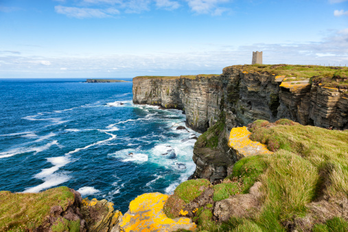 The Kitchner Memorial tower on the cliffs at Marwick Head on the west coast of the Orkney Mainland in the Orkney Islands off the northeast of Scotland. The high cliffs of Marwick Head, around 300 feet or 100 metres in height, are an important breeding ground for sea birds. The Kitchner Memorial tower was unveiled in 1926 to commemorate Lord Kitchner, British Minister of War, and the crew of HMS Hampshire who died here in 1916 during the First World War when the ship hit a mine.