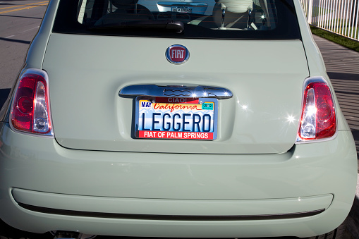 Car number without letters and numbers on the car bumper. Blank white license plate in front of the car, all logos removed, close up. The front rectangular license plate of a vehicle on the street