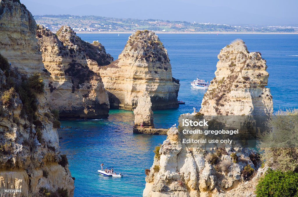 Formações rochosas com barco nos Lagos, no Algarve, Portugal - Foto de stock de Algarve royalty-free