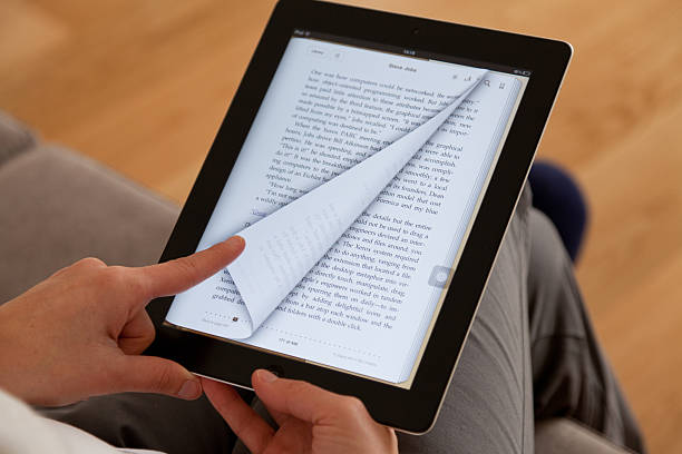 lisant un e-book - ipad apple computers digital tablet editorial photos et images de collection