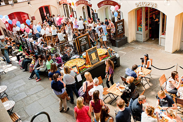 People sit on the patio of a restaurant in South Kensington, London, UK, on a sunny day.