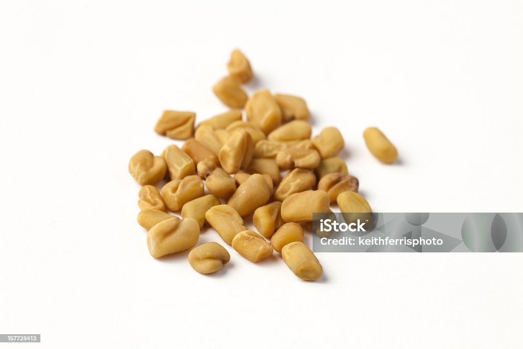 fenugreek seeds Whole fenugreek seed photographed on a white background with a macro lens. It is a spice and is a common ingredient in many curries. It also has a number of medicinal uses and is known to increase lactation in nursing mothers. Fenugreek Stock Photo