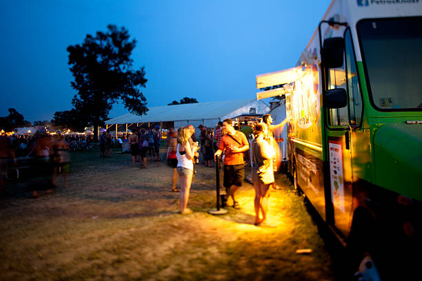 Os frequentadores de festivais obtenção de jantar do food truck - foto de acervo