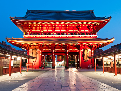 Tokyo, Japan - October 13, 2023: The closed up shops of Nakamise shopping street at night in the Asakusa district of Tokyo, Japan with glowing in the background Sensoji Temple.