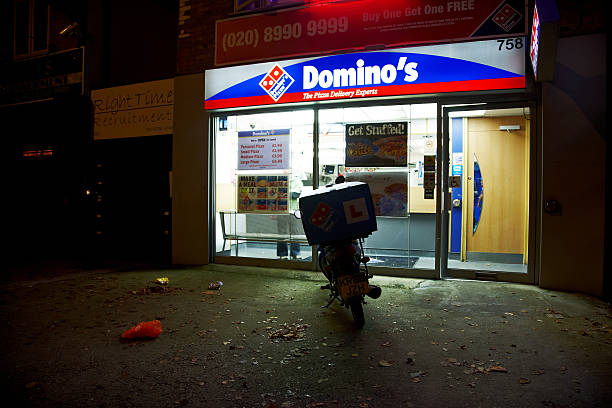 consegna pizza di dominos veicolo e ristorante a notte - dominos pizza foto e immagini stock