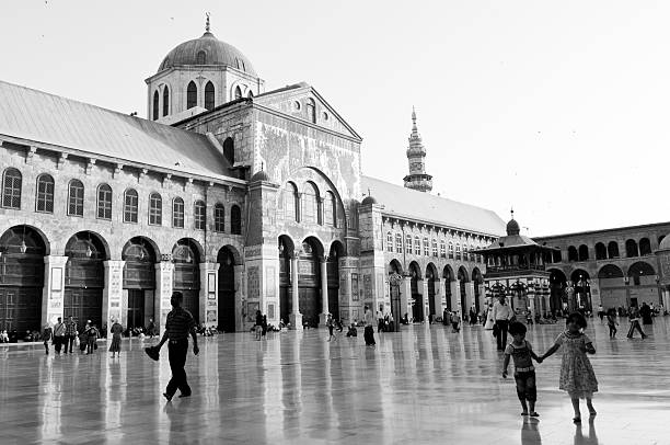 Damascus, Syria - June 13, 2010: People walk in the courtyard of the Umayyad Mosque. Built on the site of a Byzantine church in the 8th century, today it is one of the most beautiful architectural landmarks in Syria.