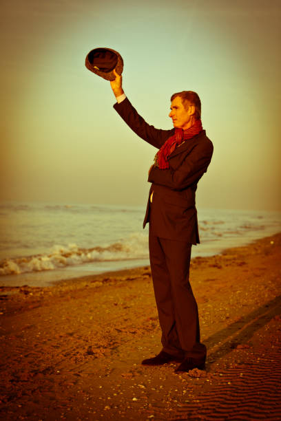 Waving man Man waiving at the beach. Dualtone processed.  scene40 stock pictures, royalty-free photos & images