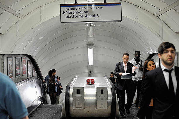 London, UK - June 26, 2018: People riding escalator up and down standing in Underground tube metro in Pimlico district area of city through tunnel