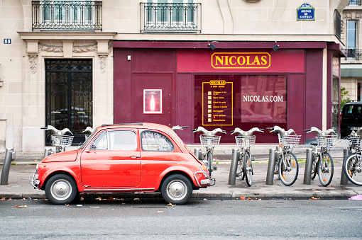 Paris, France - December 31, 2011: Fiat 500 parked on Avenue de suffren in Paris, France, Behind are city hire bicycles.