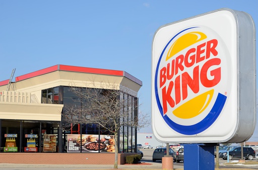 Ondara, Alicante province, Spain - DECEMBER 5, 2022: Burger King fast food restaurant illuminated at night in a shopping center, empty before dinner time.