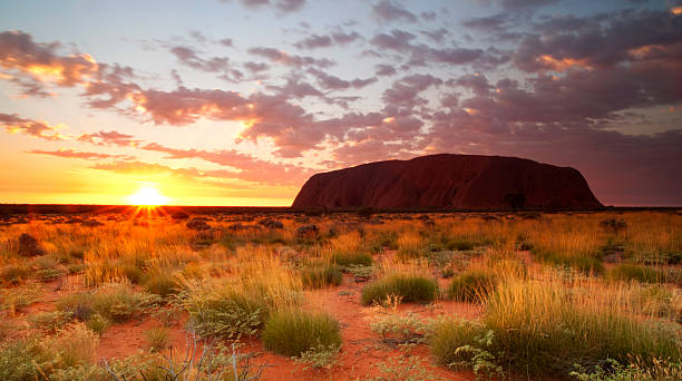 ayers rock dawn northern territory - australian outback stock-fotos und bilder