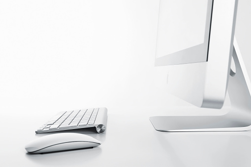 Blank screen desktop computer and laptop on wooden table with blur office background, Mock up for display or montage, 3D rendering.