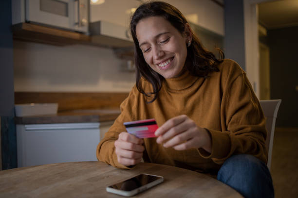 istock Cheerful  young woman doing online shopping 1577300363