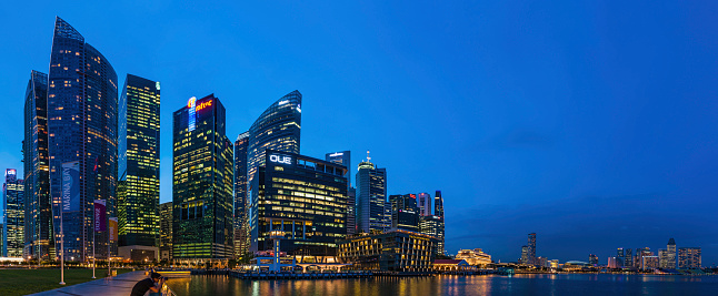 singapore. 14 th april, 2023: views of  marina bay by night, that is the most remarkable landmark of the city in singapore. it is surrounded by an avantgarde skyline and the famous marina bay sands building.