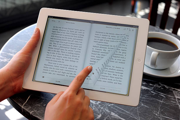 читать книгу с ipad 3 - e reader digital tablet cafe reading стоковые фото и изображения