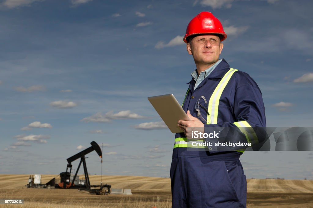 Oil and Tablet An image from the oil industry of an oil worker with a computer tablet. Mining - Natural Resources Stock Photo