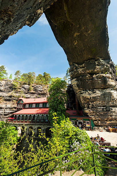 pravcicka taken Pravcicka brana, Czech Republic - May 5, 2012: Pravcicka brana (gate) is the largest (16m high) natural stone arch in europe and the most beautiful sandstone formation in czech switzerland. Beside the gate is a historical restaurant called falcon's nest. It was built in 1881. This place is one of the main attractions for tourists and hikers in the region. pravcicka stock pictures, royalty-free photos & images
