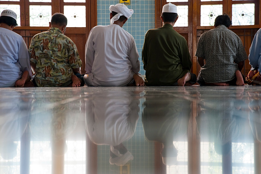 Men sit side-by-side during prayers at the main mosque in Pattani, Thailand. Photo taken in 2007.