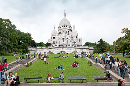 Sacré-Coeur Basilica, Montmartre, Paris, France - Tourists walking up the hill to the famous tourist attraction. It is a Roman Catholic church and basilica dedicated to the Sacred Heart of Jesus