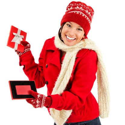 Photo of an attractive young woman in red coat, mittens and knit hat, holding an open gift box with a gift card inside with smile on her face; isolated on white.