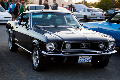 Stony Stratford,UK - June 4th 2023: 1967 white FORD MUSTANG classic car travelling on an English country road.