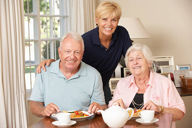 istock Senior Couple Enjoying Meal Together With Home Help 157733096