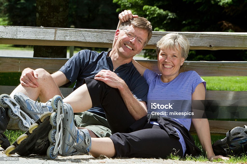 Marido y mujer relajarse al aire libre después de Patinaje con patines de ruedas - Foto de stock de 40-49 años libre de derechos