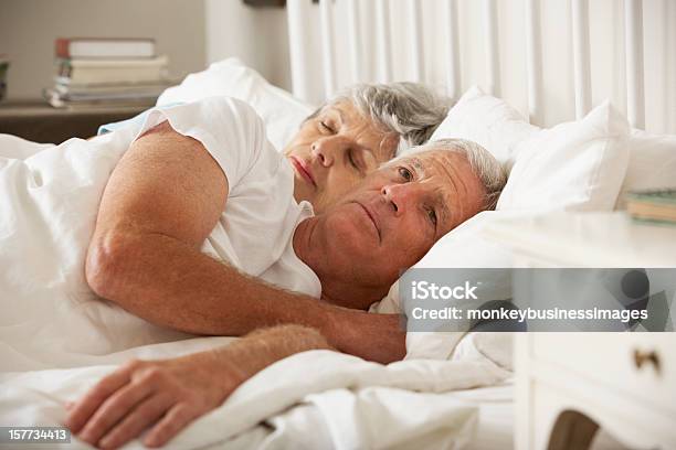 Senior Woman Tries To Be Affectionate Towards Husband In Bed Stock Photo - Download Image Now