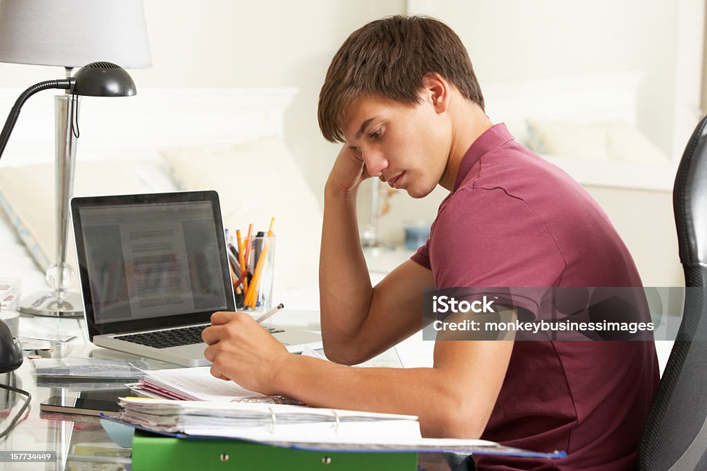 Männlicher Teenager studieren am Schreibtisch im Schlafzimmer - Lizenzfrei Akademisches Lernen Stock-Foto