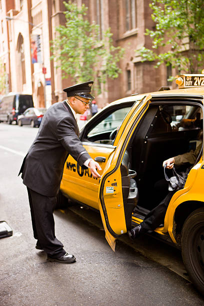 portier beim öffnen taxi ankunft in new york hotel - people traveling business travel travel new york city stock-fotos und bilder