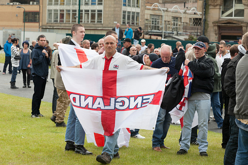 Bradford, UK - August 28, 2010: Man holding a flag at the English Defence League rally. The EDL are a far right group who held a rally in the city of Bradford, which has a large muslim population. Although the EDL said that thousands would join them, only around 800 showed up, according to police estimates.