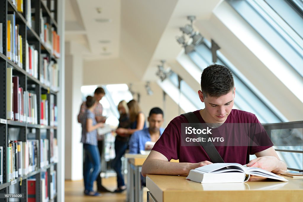 Gruppo di studenti che studiano in libreria - Foto stock royalty-free di Biblioteca