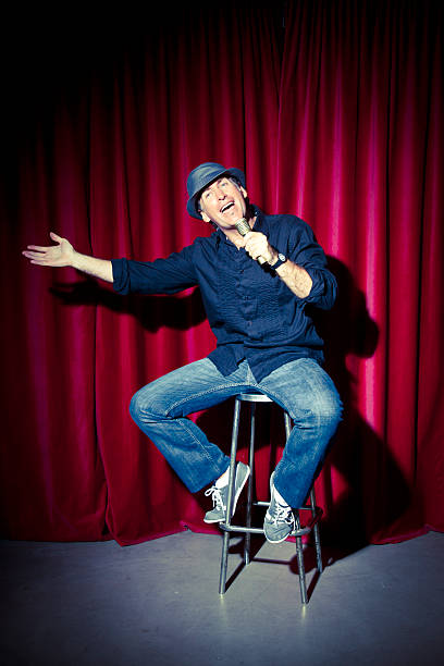 Comedian at stage Mid adult comedian telling jokes. comedian stock pictures, royalty-free photos & images