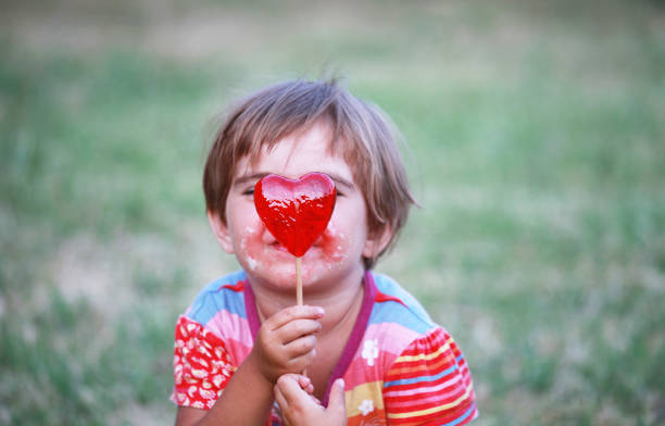 istock Cute girl hiding after a lollypop 157735366