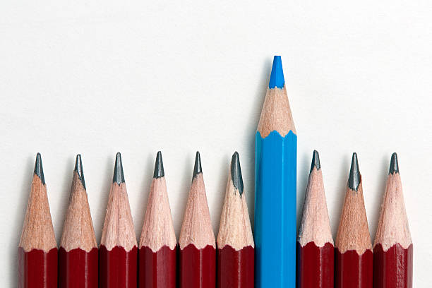istock A blue pencil standing out from a row of red pencils 157735727