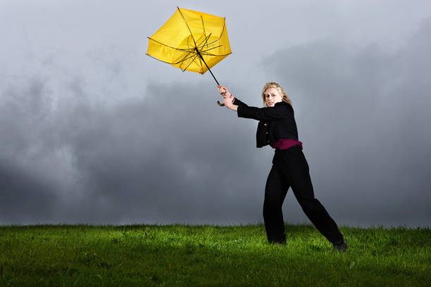 jeune femme dans un orage de perdre son de parasols jaunes - breaking wind photos et images de collection