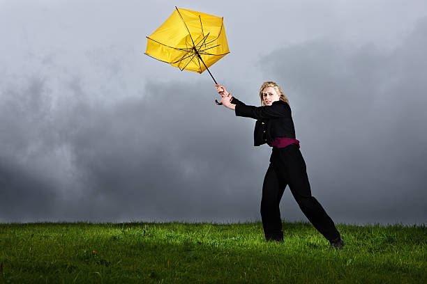 若い女性は彼女の雷雨を失わ黄色の傘 - umbrella women storm yellow ストックフォトと画像