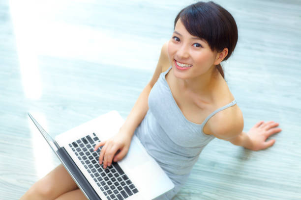 istock pretty young woman using laptop in home 157735967
