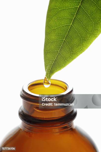 Droplet Falling From Green Leaf Into Brown Bottle Stock Photo - Download Image Now - Alternative Medicine, Aromatherapy, Aromatherapy Oil