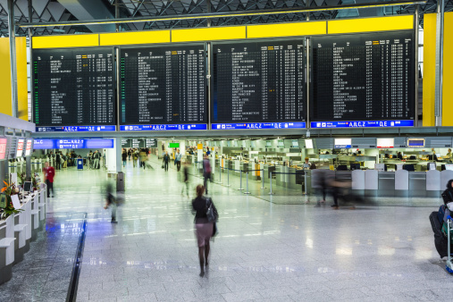 Travelers at public area at international Frankfurt Airport, the busiest airport in Germany. Longer exposure.