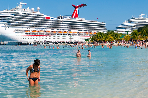Cruise ship passengers enjoy a port call in Mahogany Bay on the Caribbean island of Roatan, Honduras. The M.S. Carnival Valor, owned by Carnival Cruise Lines, is docked in the background.