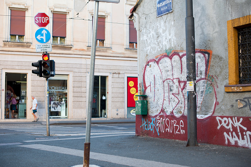 Padua, Veneto, Italy - Jun 22nd, 2023: Two women in the street and a Kenny Random's romantic graffiti on a corner of Padova city center