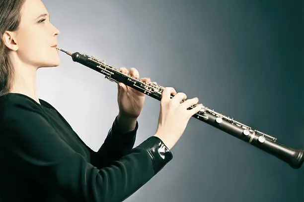 Classical musician oboe playing. Oboist with musical instrument